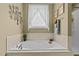 Bathroom featuring a garden tub, white tile, and a plant accent at 503 Fish Pond Ct, Rolesville, NC 27571