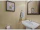 Powder room features a pedestal sink, decorative mirror, and charming artwork at 503 Fish Pond Ct, Rolesville, NC 27571