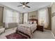 Cozy bedroom with a ceiling fan, a flower-patterned bedspread, and natural light from the windows at 503 Fish Pond Ct, Rolesville, NC 27571