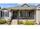 Cozy front porch featuring stone accents, a black railing, and a welcoming wreath on the front door at 503 Fish Pond Ct, Rolesville, NC 27571