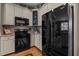 Kitchen featuring white cabinetry, black appliances, and granite countertops at 503 Fish Pond Ct, Rolesville, NC 27571