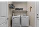 Functional laundry area featuring a washer, dryer, and overhead shelving at 503 Fish Pond Ct, Rolesville, NC 27571