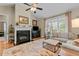 Cozy living room with fireplace, plush seating, ceiling fan, and natural light at 503 Fish Pond Ct, Rolesville, NC 27571