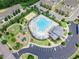 Aerial view of neighborhood pool, playground, volleyball court, and parking, surrounded by mature trees at 518 Retreat Ln, Wake Forest, NC 27587