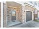 Home exterior featuring stone veneer, a gray door, and an attached one car garage at 518 Retreat Ln, Wake Forest, NC 27587