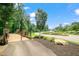 Scenic street view of lush landscaping, mature trees, and a landscaped median with colorful flowers at 518 Retreat Ln, Wake Forest, NC 27587