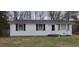 Close-up of a well-kept, one-story home's exterior with white siding, dark shutters, and a neatly trimmed lawn at 530 Broad Rd, Roxboro, NC 27573