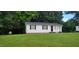 Single story house featuring a lush green lawn and a classic white exterior, surrounded by mature trees at 530 Broad Rd, Roxboro, NC 27573