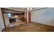 Open-concept living room view into kitchen with brown carpet and wood trim at 530 Broad Rd, Roxboro, NC 27573