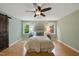 This bedroom features light green walls, hardwood floors, a ceiling fan, and windows for natural light at 5610 Frenchmans Creek Dr, Durham, NC 27713