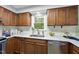 Close up of the wooden cabinets, stainless steel sink and appliances, and white subway tile in this kitchen at 5610 Frenchmans Creek Dr, Durham, NC 27713