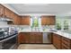 This kitchen features wood cabinets, stainless steel appliances, a window view, and stone countertops at 5610 Frenchmans Creek Dr, Durham, NC 27713