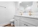 Bright bathroom with double vanity, white cabinets, gold hardware, and wood-look flooring at 5712 Wintergreen Dr, Raleigh, NC 27609