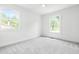 Bright bedroom featuring plush carpeting, two windows, and neutral paint at 5712 Wintergreen Dr, Raleigh, NC 27609