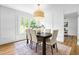 Bright dining room featuring a modern light fixture, a dark wooden table, and paneled walls at 5712 Wintergreen Dr, Raleigh, NC 27609
