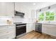 Bright kitchen featuring white cabinets, stainless steel appliances, subway tile backsplash, and quartz countertops at 5712 Wintergreen Dr, Raleigh, NC 27609