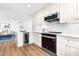 Bright kitchen featuring white cabinets, stainless steel appliances, subway tile backsplash, and quartz countertops at 5712 Wintergreen Dr, Raleigh, NC 27609