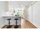 Bright kitchen featuring white cabinets, stainless steel appliances, quartz countertops, an island with seating and barn door at 5712 Wintergreen Dr, Raleigh, NC 27609