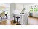 Bright kitchen featuring white cabinets, stainless steel appliances, quartz countertops and an island with seating at 5712 Wintergreen Dr, Raleigh, NC 27609