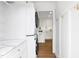Bright laundry room featuring a stacked washer dryer, access to the kitchen, and white cabinets at 5712 Wintergreen Dr, Raleigh, NC 27609