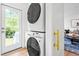 Bright laundry room featuring a stacked washer dryer, access to outside, and view into living space at 5712 Wintergreen Dr, Raleigh, NC 27609