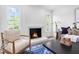 Bright living room with fireplace, stylish decor, hardwood floors and windows to exterior at 5712 Wintergreen Dr, Raleigh, NC 27609