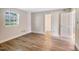 A bright bedroom features laminate floors, a window, and white trim work at 5804 Falls Of Neuse Rd # E, Raleigh, NC 27609
