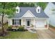 Aerial view of a yellow home boasting dormers, manicured lawn, and an attached garage at 59 Tuscarora Ln, Clayton, NC 27520