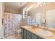 Bathroom with dual sinks, shower and floral shower curtain at 59 Tuscarora Ln, Clayton, NC 27520