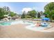Community pool featuring waterslides, a splash pad, and spacious lounging areas at 59 Tuscarora Ln, Clayton, NC 27520