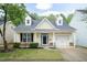 Charming yellow home featuring a well-manicured lawn, dormers, and an attached garage at 59 Tuscarora Ln, Clayton, NC 27520
