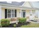 Inviting front porch featuring black shutters, flower pots, and lovely landscaping at 59 Tuscarora Ln, Clayton, NC 27520