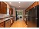 Well-lit kitchen with warm wood cabinets, tile flooring, and stainless steel appliances at 59 Tuscarora Ln, Clayton, NC 27520