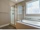 Bathroom with garden tub, glass shower, tile floor, and modern fixtures at 65 N Wilders Ridge Way, Clayton, NC 27527