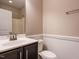 Bathroom featuring a vanity with dark cabinets, toilet, and shower with white surround at 65 N Wilders Ridge Way, Clayton, NC 27527