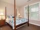 Bedroom features a four-poster bed, floral bedding, and natural light at 65 N Wilders Ridge Way, Clayton, NC 27527