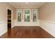 Dining room with hardwood floors, white wainscoting and natural light streaming through the windows at 65 N Wilders Ridge Way, Clayton, NC 27527