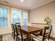 Bright dining room with a large wooden table, six chairs, and natural light from the windows at 65 N Wilders Ridge Way, Clayton, NC 27527