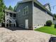 Exterior view showcases the house with a stone patio, screened porch, and lush green lawn at 65 N Wilders Ridge Way, Clayton, NC 27527