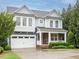 Charming two-story home featuring a two-car garage, stone accents, and lush front yard landscaping at 65 N Wilders Ridge Way, Clayton, NC 27527