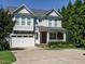 Charming two-story home with a two-car garage and covered porch with stone accents at 65 N Wilders Ridge Way, Clayton, NC 27527