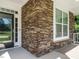 Close-up of the front porch with stone pillars and a view of the front door and window at 65 N Wilders Ridge Way, Clayton, NC 27527