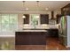 Open kitchen with granite countertops, dark wood cabinets, large island, and stainless steel appliances at 65 N Wilders Ridge Way, Clayton, NC 27527