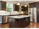 Beautiful kitchen features granite countertops, dark cabinets, large island, and stainless steel appliances at 65 N Wilders Ridge Way, Clayton, NC 27527