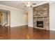 Bright living room with hardwood floors, a stone fireplace, and views of the staircase at 65 N Wilders Ridge Way, Clayton, NC 27527