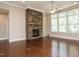 Spacious living room with hardwood floors, a stone fireplace, and plenty of natural light at 65 N Wilders Ridge Way, Clayton, NC 27527
