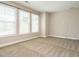 Spacious living room with neutral walls, three windows, and plush carpeting at 65 N Wilders Ridge Way, Clayton, NC 27527