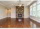 Open-concept living room with hardwood floors and a stone fireplace with an adjacent staircase at 65 N Wilders Ridge Way, Clayton, NC 27527