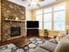 Inviting living room featuring stone fireplace, large windows, and hardwood floors at 65 N Wilders Ridge Way, Clayton, NC 27527