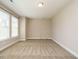 Open living room with neutral walls and carpet, featuring two windows for natural light at 65 N Wilders Ridge Way, Clayton, NC 27527